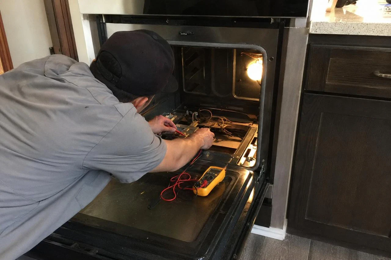 Oven Repair technician diagnosing a oven problem