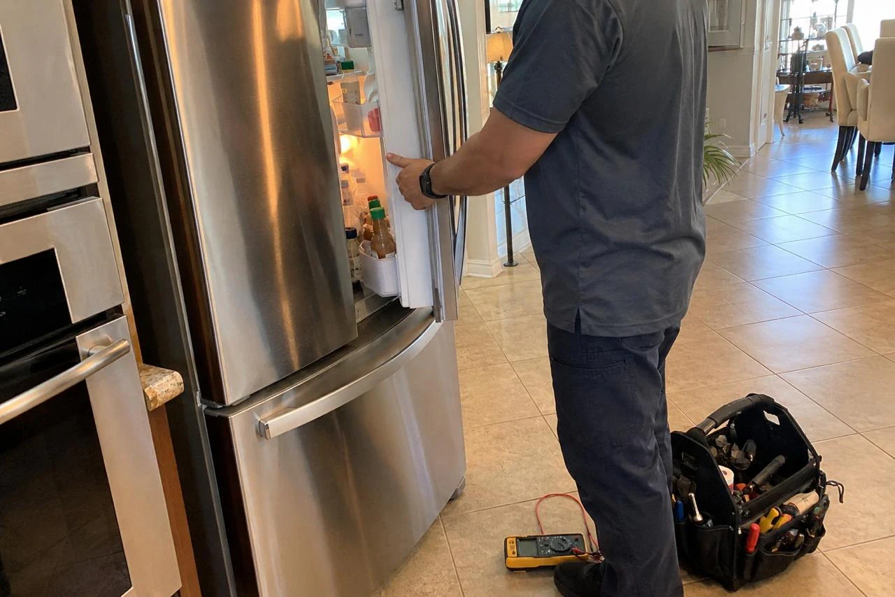 Refrigerator Repair technician diagnosing a refrigerator problem